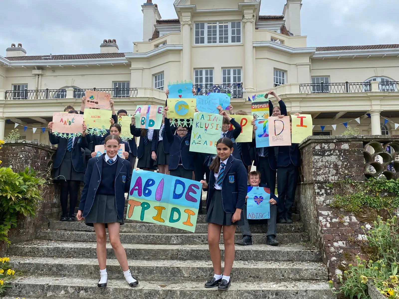 Image of Gregg School students outside holding up poster they created as part of ABIDE week.