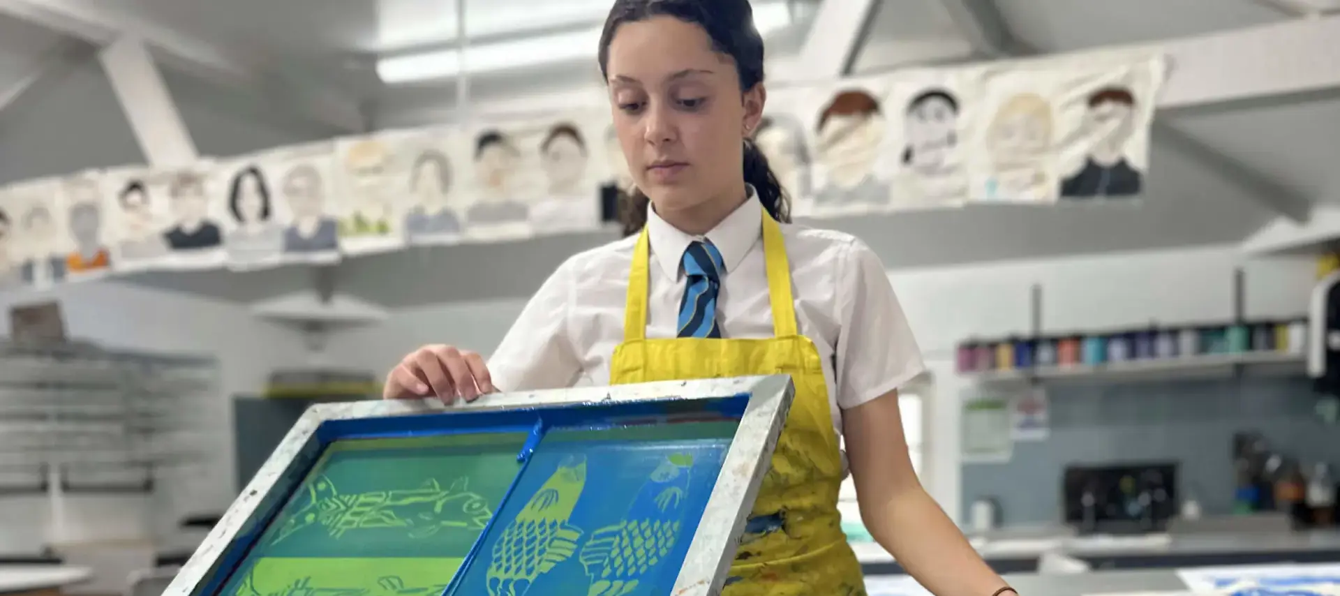 Student screen printing in art class at The Gregg School